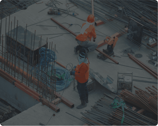 Two construction workers in hardhats conversing